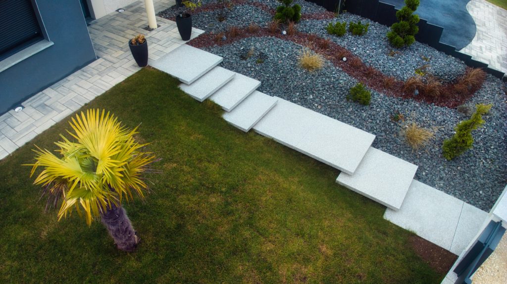 julien-nature-services - vu drone d'un aménagement paysagé avec escalier en dalles, jardin avec des cailloux et palmier dans l'herbe