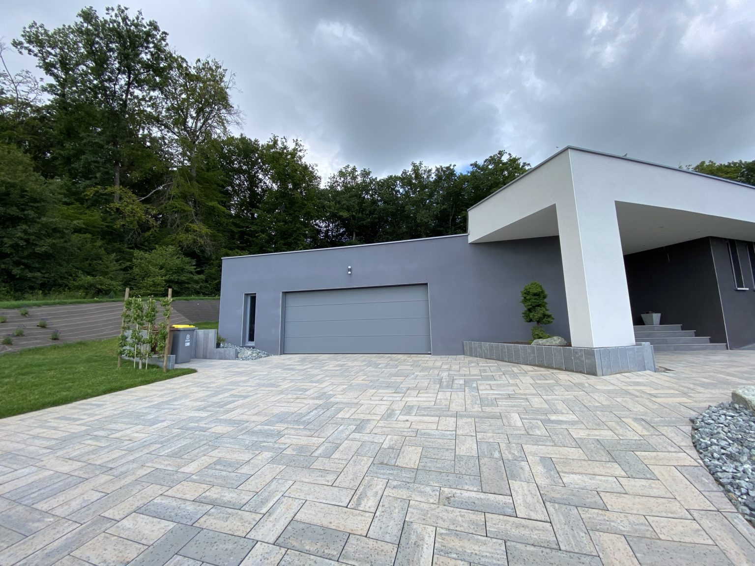 Cour en dalles devant une maison contemporaine
