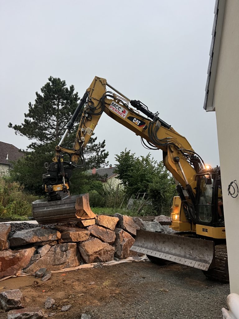 julien-nature-services - engin de chantier empilant des grosses pierres