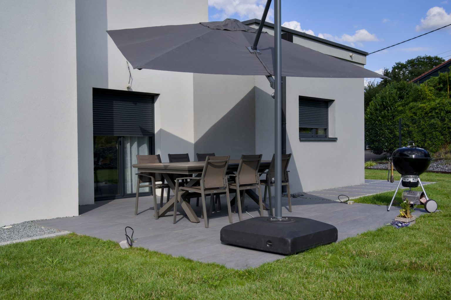 Terrasse en dalles aménagée avec salon de jardin